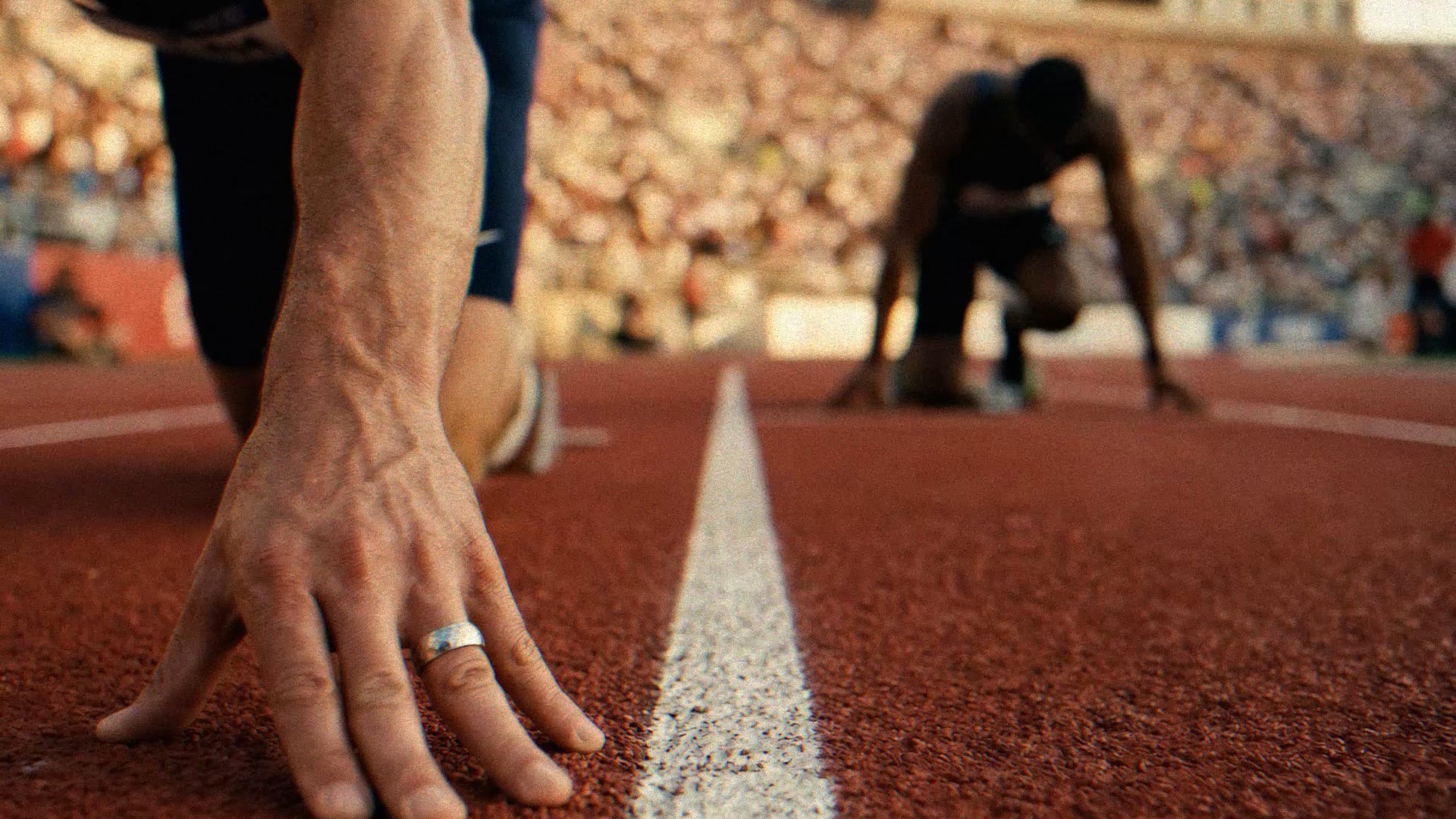 RUIK Federals — synthetic athletics spot, two sprinters at the starting line